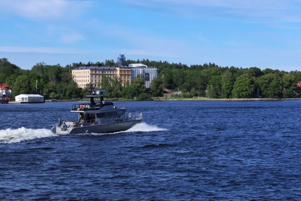 Motorbåt i fart på blått vatten i Stockholms skärgård en solig sommardag