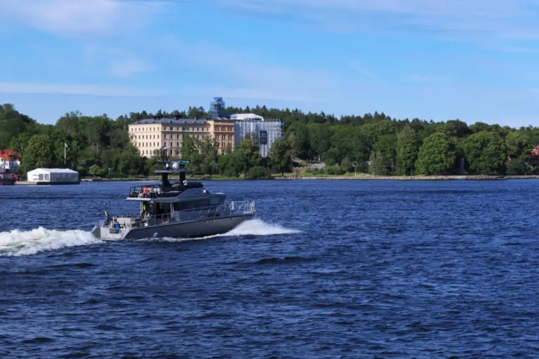 Motorbåt i fart på blått vatten i Stockholms skärgård en solig sommardag