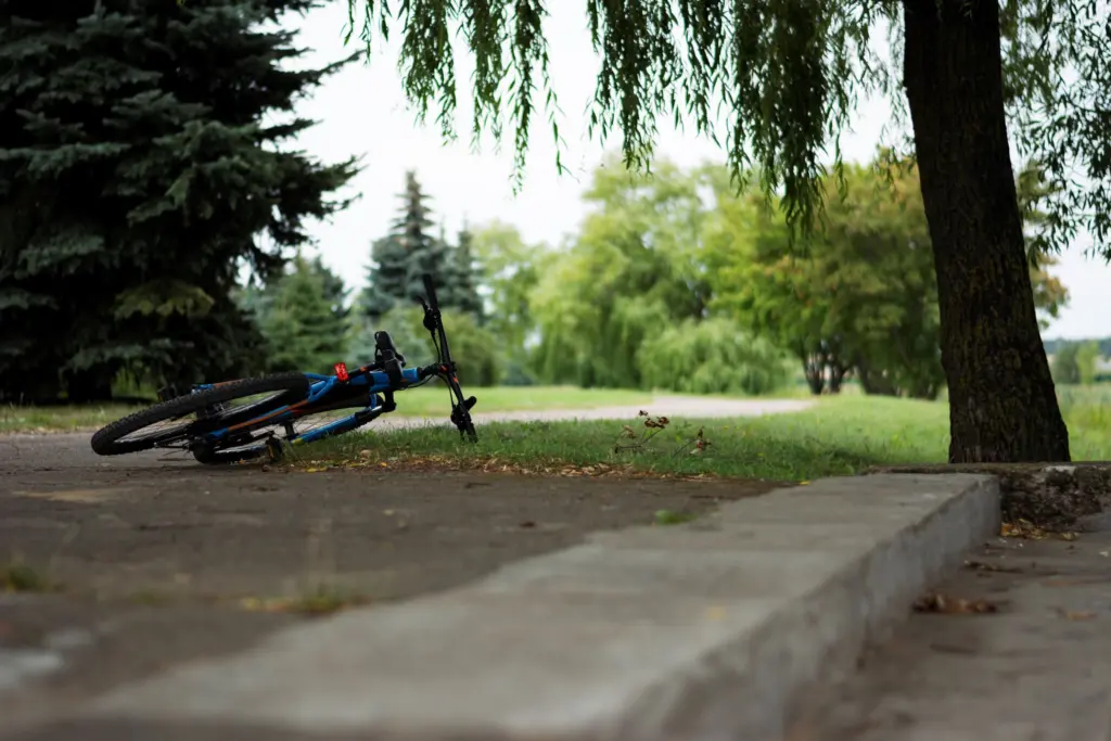En cykel ligger vält på en gångväg i en park, en vardaglig olycka på fritiden som försäkringen via jobbet inte täcker