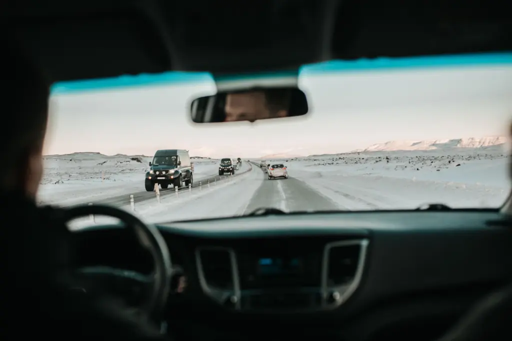 Vy genom vindrutan på en snöig landsväg med mötande trafik, körsträckan är en av sakerna som styr priset på bilförsäkringen