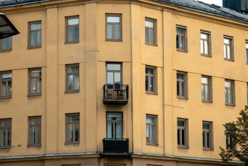 Gul fasad på ett äldre stenhus i Stockholm med balkonger, bostäder som har lånats till under många olika räntenivåer