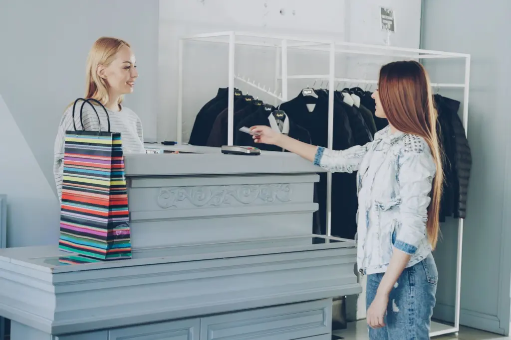 Kund betalar med kort vid kassan i en klädbutik, delbetalning och kortkredit vid köp