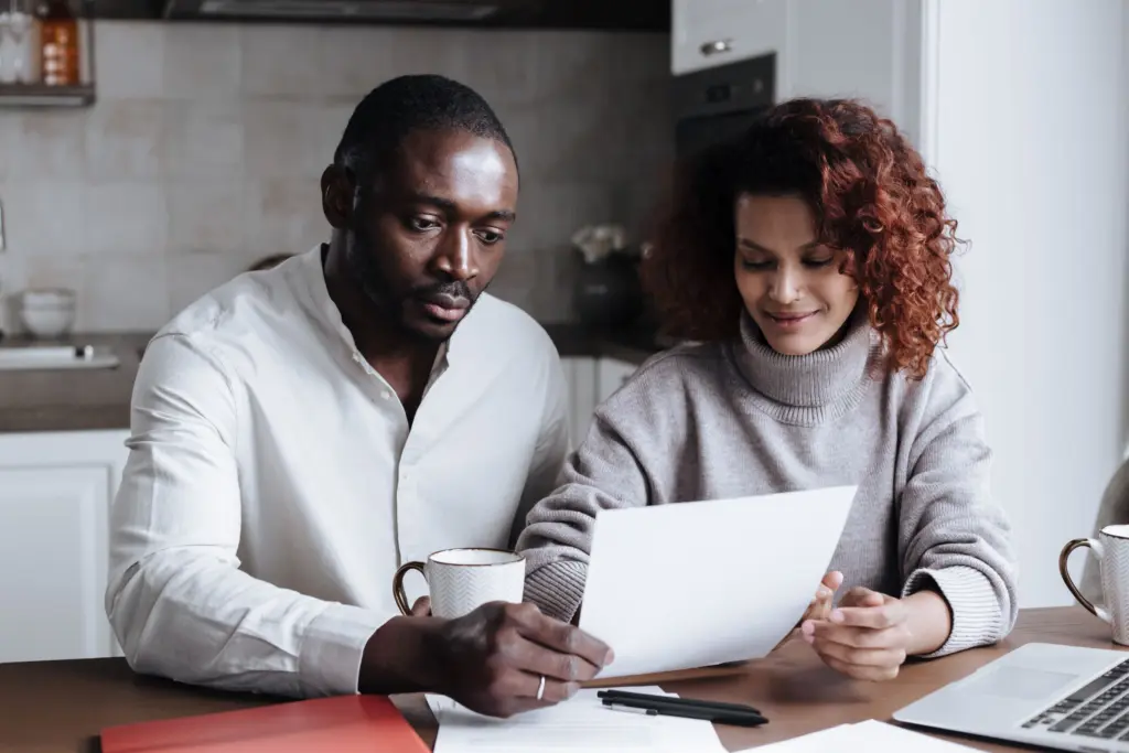 Ett par läser igenom ett papper tillsammans vid köksbordet