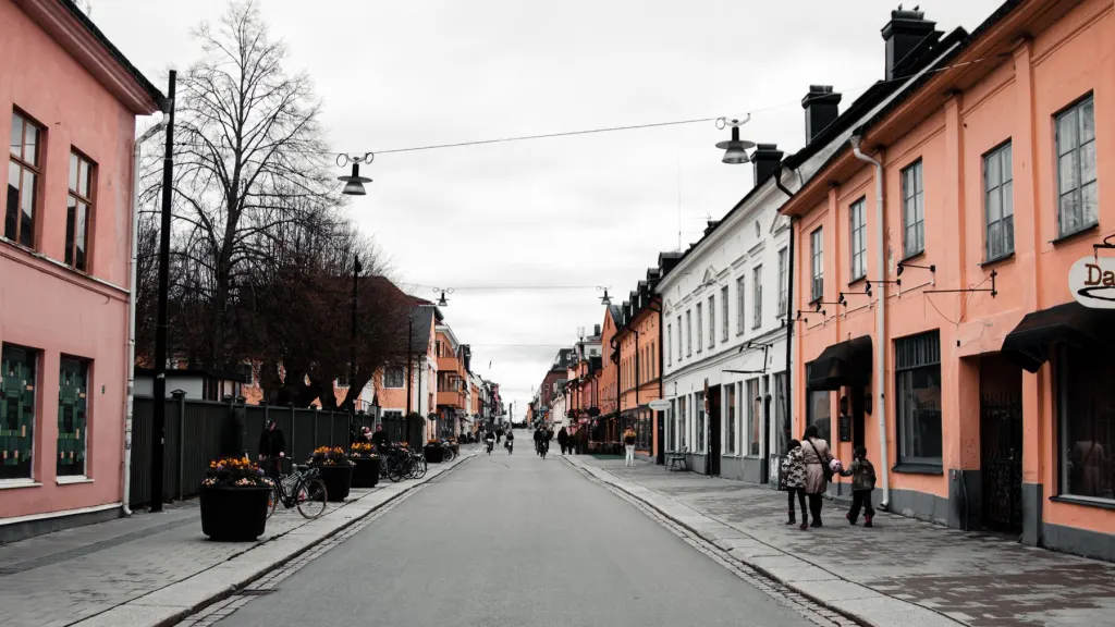 Gata med låga flerbostadshus i pastellfärger i Uppsala en gråmulen dag, en bild för att leta bostad med lånelöfte