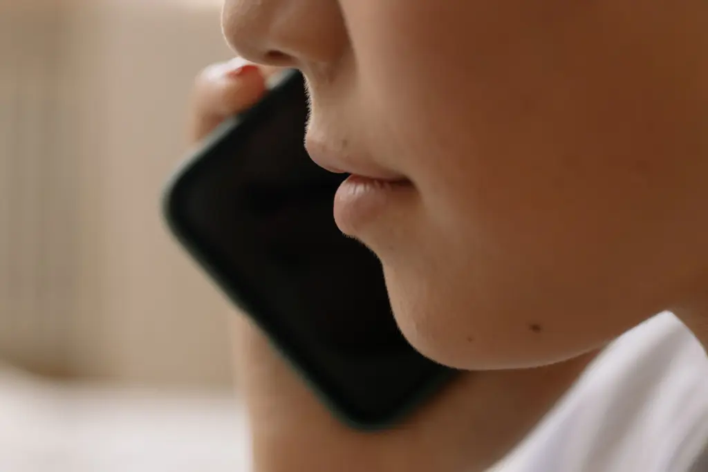 Närbild på en person som pratar i mobiltelefon