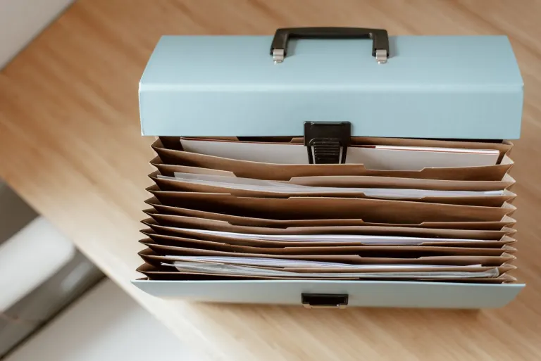 Dokumentmapp med samlade papper på ett träbord, som när flera lån samlas i ett samlingslån